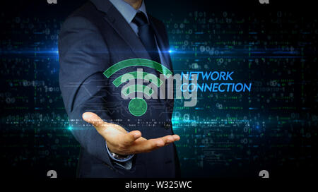 A businessman in a suit touch the screen with wi-fi symbol hologram. Man using virtual display interface. Wi fi, mobile communication, internet access Stock Photo