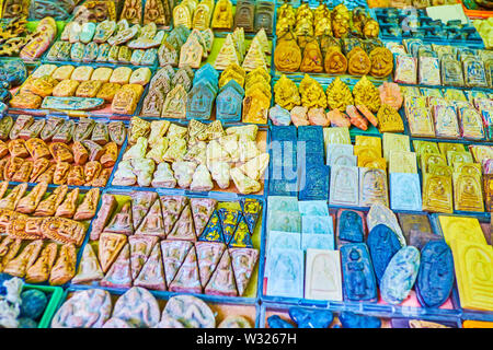 The variety of amulents from different materials on buddhist theme in Tha Prachan Amulet Market in Bangkok, Thailand Stock Photo