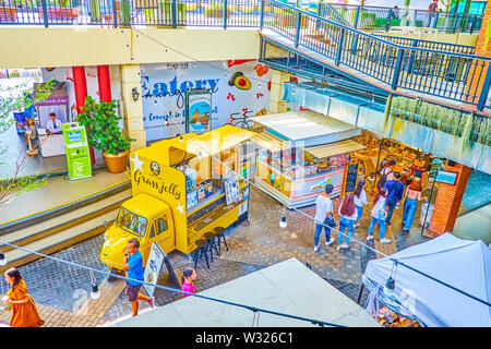 BANGKOK, THAILAND - APRIL 22, 2019: The Tha Maharaj pier boasts cozy outdoor food court gallery with numerous stalls with variety of dishes, beverages Stock Photo