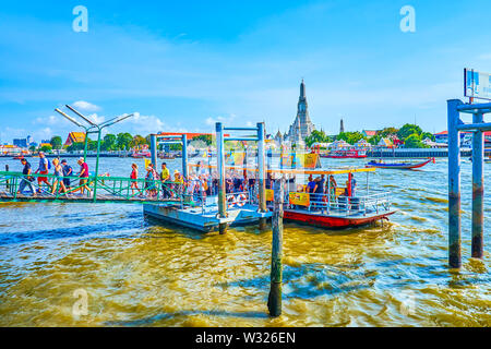 BANGKOK, THAILAND - APRIL 22, 2019: The group of tourists get off from the ferry at the pier of Chao Phraya river, on April 22 in Bangkok Stock Photo