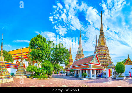 BANGKOK, THAILAND - APRIL 22, 2019: Panorama of Phra Maha Chedi shrine, that consists of large stupas, covered with colorful tiles, surrounded with wa
