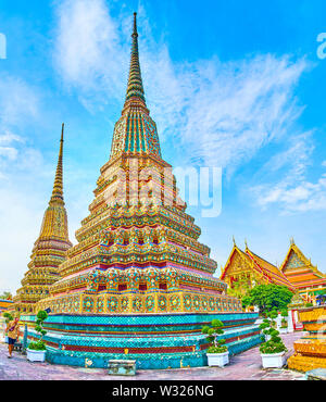 BANGKOK, THAILAND - APRIL 22, 2019: The beautiful stupas, covered with colorful glazed tiles of Phra Maha Chedi shrine are one of the most notable lan