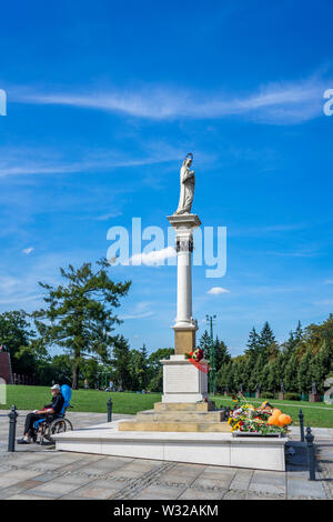 A man in his wheelchair at the foot of the Monument of the virgin Mary at Jasna Góra sanctuary during the celebration of the assumption of Mary in Aug Stock Photo