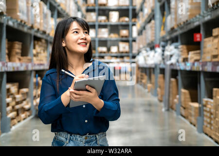 Young asian woman auditor or trainee staff work looking up and checks the number of items store by digital tablet. Asian owner or small business conce Stock Photo
