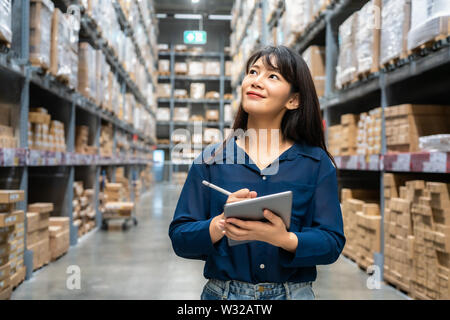 Young asian woman auditor or trainee staff work looking up and checks the number of items store by digital tablet. Asian owner or small business conce Stock Photo