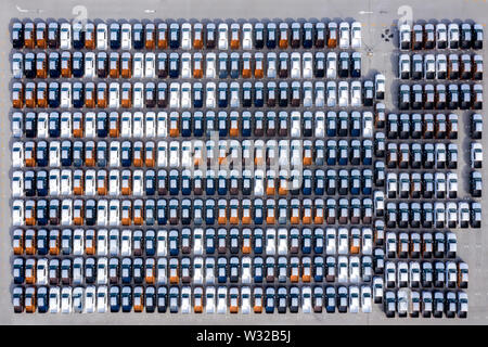 Aerial top view new cars lined up in the port for import export business logistic and transportation by ship in the open sea. New cars from the car fa