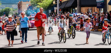 Wide panorama view of childen riding decorated bikes; Annual Fourth of July Parade in the small mountain town of Salida; Colorado; USA Stock Photo