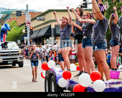 High school cheerleaders ride float in annual Fourth of July Parade; small mountain town of Salida; Colorado; USA Stock Photo