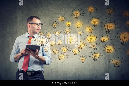 Happy business man using tablet computer having brilliant ideas being creative Stock Photo