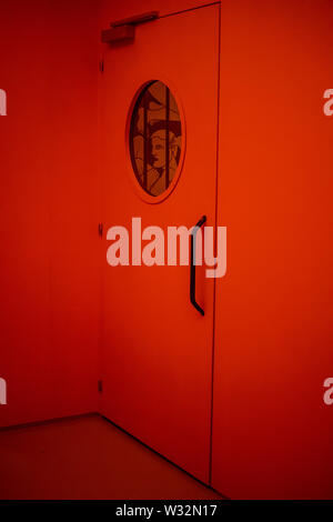 Geneva, Switzerland, March 2019 door with porthole in jail, red danger light, Prison exhibition - International Red Cross and Red Crescent Museum Stock Photo