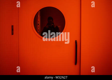 Geneva, Switzerland, March 2019 door with porthole in jail, red danger light, Prison exhibition - International Red Cross and Red Crescent Museum Stock Photo