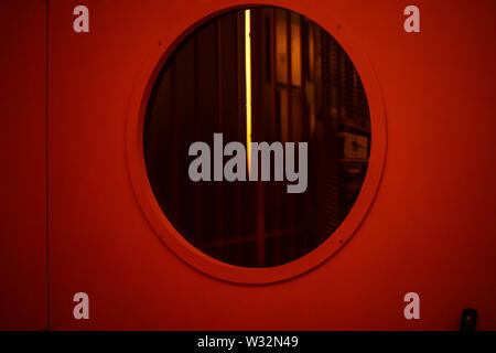 Geneva, Switzerland, March 2019 door with porthole in jail, red danger light, Prison exhibition - International Red Cross and Red Crescent Museum Stock Photo