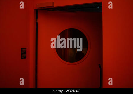 Geneva, Switzerland, March 2019 door with porthole in jail, red danger light, Prison exhibition - International Red Cross and Red Crescent Museum Stock Photo