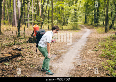 Young woman having trouble feeling knee pain during travel in forest ...