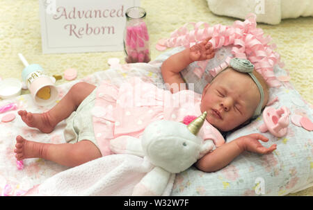 Layton, Utah, USA. 11th July, 2019. A reborn baby doll is displayed in the contest hall at the 6th Annual R.O.S.E International Doll Expo, a showcase for ultra realistic ''reborn'' baby dolls. Fashioned meticulously from viny and silcone, and weighted with glass beads and other materials for maximum realism, these collectible dolls have also been employed as emotional, cuddle therapy for dementia patients. Credit: Brian Cahn/ZUMA Wire/Alamy Live News Stock Photo