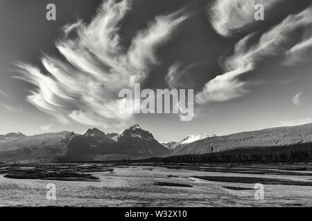 Cirrus clouds over the Chugach Mountains and the Lowe River at dawn in Southcentral Alaska. Stock Photo