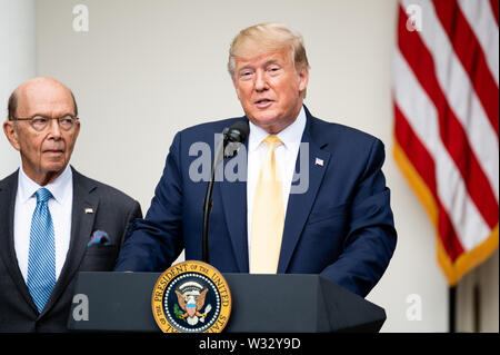 President Donald Trump announcing that he is signing an Executive Order to enable the government to count citizens in the country, behind him stands Secretary of Commerce Wilbur Ross, in the Rose Garden at the White House. Stock Photo