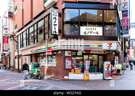 Tokyo, USA - April 4, 2019: Shinjuku city district ward with 7-eleven or Seven Eleven convenience store shop storefront or facade with people walking Stock Photo