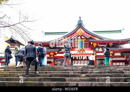 Tokyo, Japan - March 30, 2019: Hie Shinto shrine with stone steps or stairs and people walking by temple entrance Stock Photo