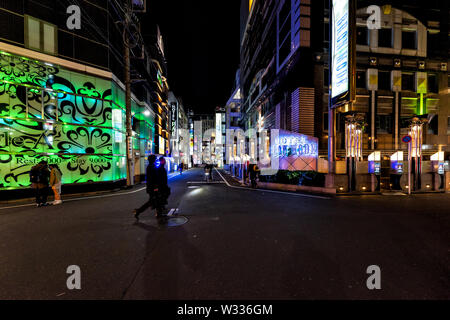Shinjuku, Japan - April 4, 2019: Love hotels Blon Mode and Style A with people walking on narrow alley lane street of Kabukicho at night in Tokyo Stock Photo