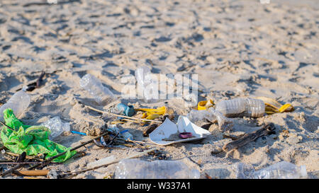 Trash and used plastic bottles on the beach. Environmental pollution. Ecological problem, rubbish on beach line. Stock Photo