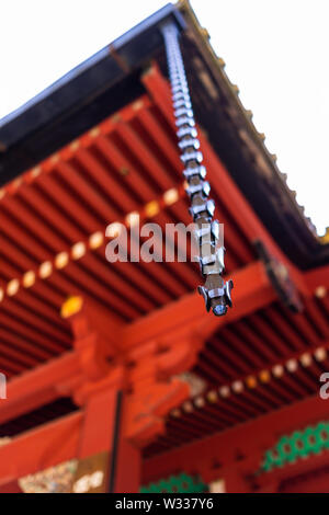 Rain chain downspout hanging from Japanese Shinto temple shrine eaves roof in Nikko, Japan Stock Photo