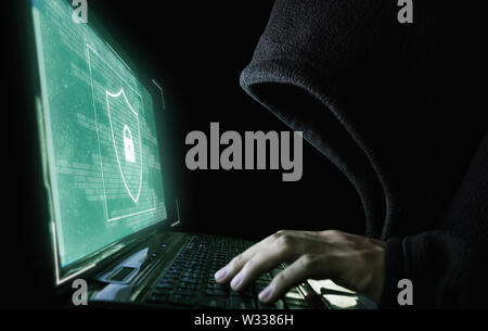 Digital data security system and protection. Anonymous hacker try to hacking on computer laptop Stock Photo