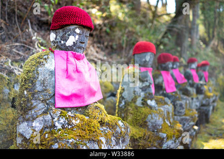 Famous stone and red Jizo statues in Kanmangafuchi Abyss, Nikko, Tochigi in Japan with hats, many figures protecting the dead Stock Photo