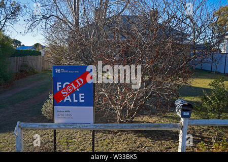 sold sticker across a sold sign outside a house in the northern new south wales town of Glen Innes, australia Stock Photo