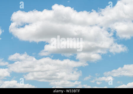 Isolated white large big cloud formations in blue sky cloudscape skyscape looking up during day in Arkansas Stock Photo