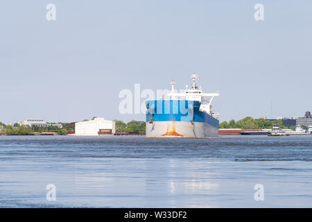 New Orleans, USA - April 23, 2019: Large cargo industrial freight ship, boat or vessel on Mississippi river in harbor or port in summer Stock Photo