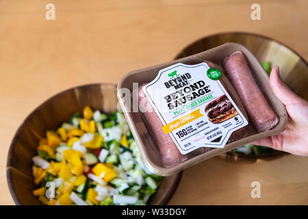 Aspen, USA - June 29, 2019: Beyond meat sausage plant-based protein brat original package with woman holding brand by salad bowls Stock Photo