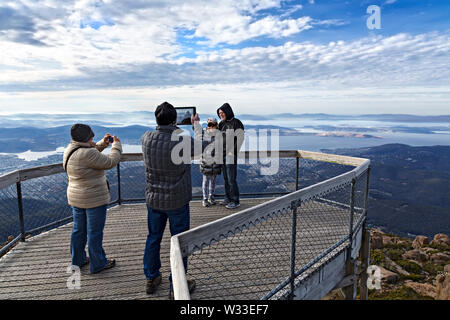 Hobart Australia / Tourists enjoy the spectacular view over Hobart from the summit of Mount Wellington. Stock Photo