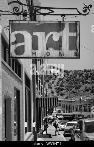 The Art Home store's overhead metal sign frames Main street with shoppers and tourists with the 'B' on Chihuahua hill looking on in the old mining tow Stock Photo