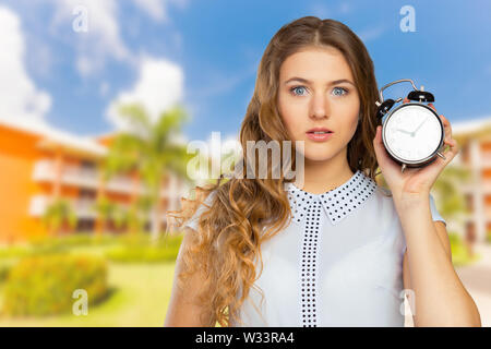 young woman holding a clock. time management concept Stock Photo