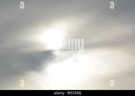 Hazy  diffused sun trying to shine through thin sheet  of cloud, makes abstract  patterns Stock Photo