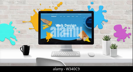 Web design studio with modern web site theme on computer display with color drops on brick wall. Concept of creating modern and colorful web sites. Stock Photo