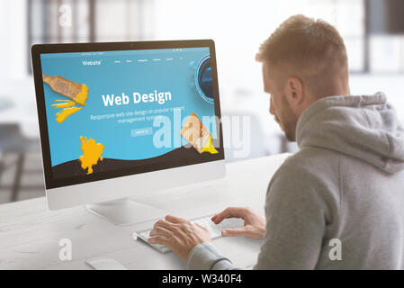 Guy work on modern web site on computer in graphic, web design studio office. Concept. Stock Photo