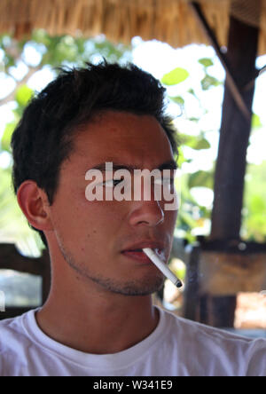 Handsome young man with a tan and a cigarette in a bar Stock Photo