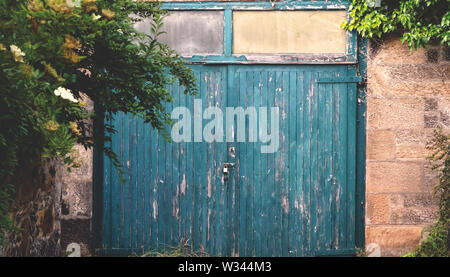 An old wooden garage door made of planks that are severely weathered Stock Photo
