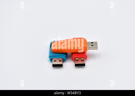 USB flash memory drives with colours, orange, blue and red, on a white background. Stock Photo