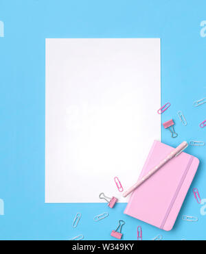Beautiful office stationery flat lay with pink notebook, striped pen, sticky notes, paper clip Stock Photo