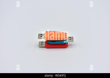 USB flash memory drives with colours, orange, blue and red, on a white background. Stock Photo