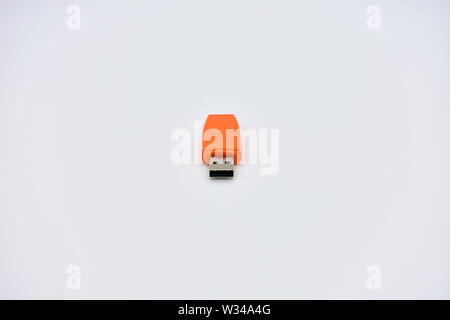 Orange USB flash memory drive on a white background. Stock Photo