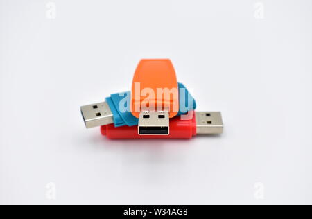 USB flash memory drives with colours, orange, blue and red, on a white background. Stock Photo