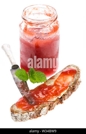 Strawberry jam in jar with bread, knife and mint Stock Photo