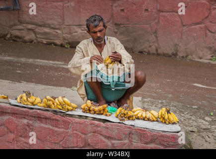 Man sitting on a roadside in Kathmandu selling bananas Stock Photo