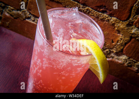 Pink Italian soda pop beverage with ice and biodegradeable paper straw Stock Photo