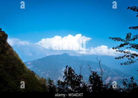 Himalayan valley mountain range background. Storm cloud over mountain ridge in blue sky. Beauty of wild east asian indian nature. Dreamy Fluffy weathe Stock Photo