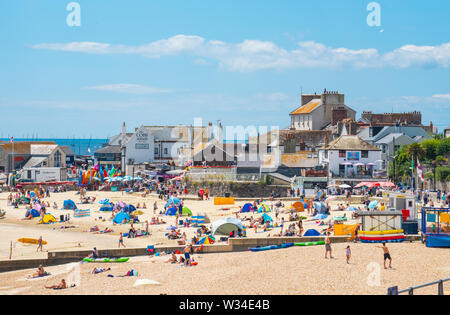 Lyme Regis, Dorset, UK. 12th July, 2019. UK Weather: Scorching hot sunshine and blue sky at Lyme Regis. Visitors flock to the sandy beach to enjoy the hot and sunny weather. Credit: Celia McMahon/Alamy Live News Stock Photo